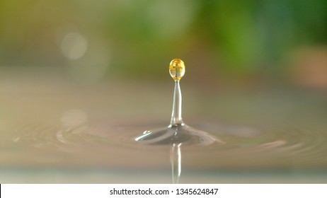 MACRO, DOF: Tiny Transparent Droplets Of Oil Fall Into A Kitchen Sink Full Of Cold Water. Cinematic Shot Of Water Droplets Creating A Beautiful Ripple In The Sink After Someone Leaves The Tap Open.