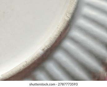Macro extreme close-up of a rustic ceramic pottery piece, showing intricate ribbed texture and unglazed rim detail.