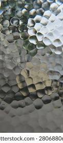 Macro full frame horizontal view of a premium hammered glass surface featuring a mesmerizing organic geometric cellular pattern with distinct pentagonal and hexagonal facets. This high-resolution creative stock photograph captures intricate vitreous textures, elegant silver-grey tones, sophisticated metallic light reflections, and authentic industrial mineral imperfections under soft, dynamic daylight conditions. This sophisticated artistic digital asset is ideal for corporate high-tech website headers, modern artificial intelligence research presentation slides, innovative big data analytics agency banners, and advanced quantum computing development brochures. A versatile minimalist backdrop perfectly suited for premium automotive marketing materials, high-end architectural interior design presentations, rustic restaurant menus, and sophisticated graphic design templates. The clean neutral color palette and rich tactile details create a harmonic, luxurious, and ultra-modern visual experience, emphasizing structural excellence, sustainable materials, classic engineering design, and contemporary urban living aesthetics. This versatile visual copy space asset is perfect for motivational success quotes, interactive digital media headers, environmental campaign materials, luxury real estate branding packages, and conceptual fine art portfolios. Carefully engineered with technical precision and harmonic color balance to easily satisfy strict microstock platform quality inspections, providing creative directors, content editors, publishing houses, and corporate media designers worldwide with a clean, high-impact, and universally recognized industrial texture asset representing pure design perfection