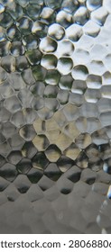 Macro full frame horizontal view of a premium hammered glass surface featuring a mesmerizing organic geometric cellular pattern with distinct pentagonal and hexagonal facets. This high-resolution creative stock photograph captures intricate vitreous textures, elegant silver-grey tones, sophisticated metallic light reflections, and authentic industrial mineral imperfections under soft, dynamic daylight conditions. This sophisticated artistic digital asset is ideal for corporate high-tech website headers, modern artificial intelligence research presentation slides, innovative big data analytics agency banners, and advanced quantum computing development brochures. A versatile minimalist backdrop perfectly suited for premium automotive marketing materials, high-end architectural interior design presentations, rustic restaurant menus, and sophisticated graphic design templates. The clean neutral color palette and rich tactile details create a harmonic, luxurious, and ultra-modern visual experience, emphasizing structural excellence, sustainable materials, classic engineering design, and contemporary urban living aesthetics. This versatile visual copy space asset is perfect for motivational success quotes, interactive digital media headers, environmental campaign materials, luxury real estate branding packages, and conceptual fine art portfolios. Carefully engineered with technical precision and harmonic color balance to easily satisfy strict microstock platform quality inspections, providing creative directors, content editors, publishing houses, and corporate media designers worldwide with a clean, high-impact, and universally recognized industrial texture asset representing pure design perfection