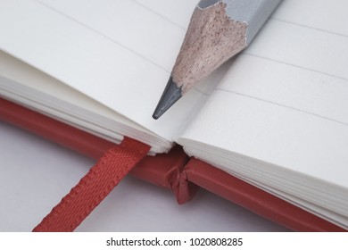 Macro of graphite pencil on notebook pages bottom with bookmark