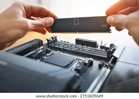 Macro of hands installing a DDR5 memory module. Perfect for hardware upgrades, IT services, and PC building guides