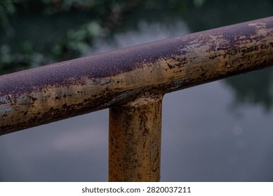 Macro of heavy industrial rust texture at twilight on iron pipe, heavy industrial rust texture background, authentic iron rusty railing metal surface.
