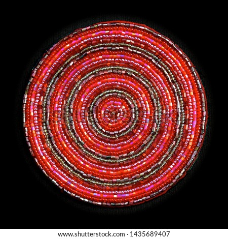 Macro image of a circular pink beaded coaster with small, glass irridescent beads sewn in concentric circles, isolated on a black background. 