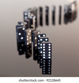 Macro image of dominos on a black reflactive surface and standing in a row - Powered by Shutterstock