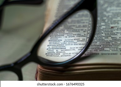macro image of an english to spanish dictionary with glasses focusing only on the word perseverance