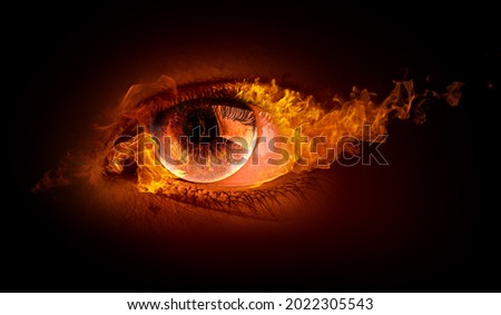 Macro image of human eye with fire flames . Mixed media