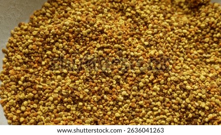 Macro image showcasing a close-up of bee pollen granules in various shades of yellow and brown, illustrating the natural texture and detail of this nutrient-rich food product
