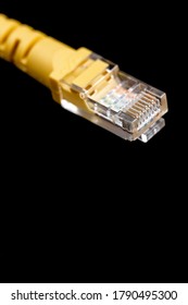 Macro image of yellow network plug over black background. Fiber optic.