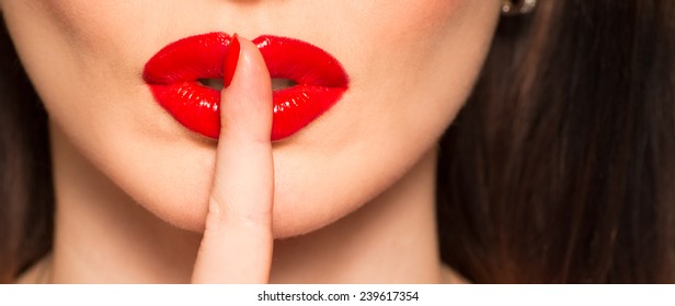 Macro Of Lips With Red Lipstick And A Finger Showing Hush And Silence