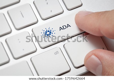 Macro of male hand pressing computer key with Cardano(ADA) currency symbol and text. Cryptocurrency and fast internet concept.