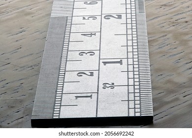 Macro Metal Ruler With Inch And Centimeter Marks On Wood Background