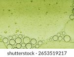 Macro microscope green bubble texture, Close-up Green bubbles and drops oil background . blue green water bubbles, close up golden oil drop for cosmetic