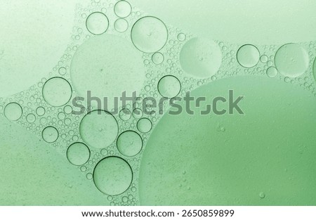 Macro microscope green bubble texture, Close-up Green bubbles and drops oil background . blue green water bubbles, close up golden oil drop for cosmetic