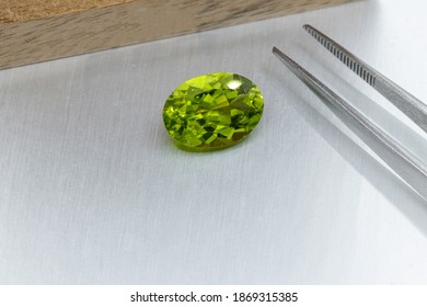 macro mineral faceted stone cut Peridot on a gray background close-up