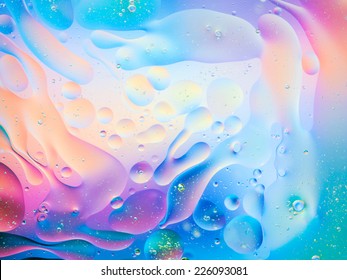 macro of oil mixed with water on colorful gradient background