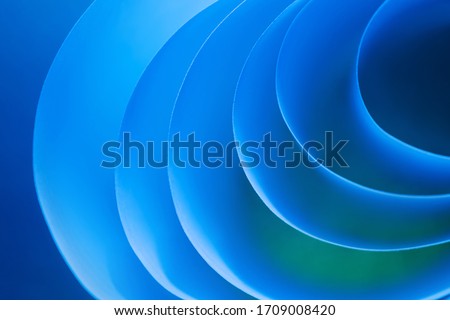 Macro photo. Abstract minimalistic background - paper art. Waves, paper cut. Single Frame from sheets of paper illuminated by neon light. Minimalism, copyspace. 3D effect. 