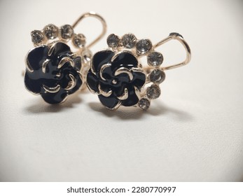 macro photo of black luxury earrings in the shape of flower petals, very beautifully photographed on a white background,