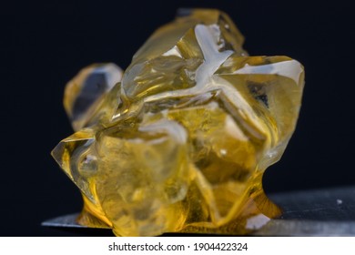 Macro photo of cannabis fresh frozen whole plant live resin THC-a crystals and terpene sauce. 