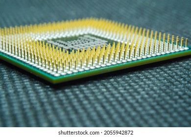 Macro photo of computer or laptop CPU microprocessor processor. Close-up of metallic gold pins and green PCB of computer processor. Semiconductors, pins and connectors. Selective focus. 