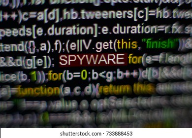 Macro photo of computer screen with program source code and highlighted SPYWARE inscription in the middle. Script on the screen with virus in it. Cyber security concept. Technology background