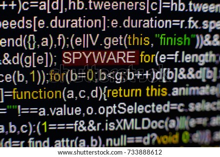 Macro photo of computer screen with program source code and highlighted SPYWARE inscription in the middle. Script on the screen with virus in it. Cyber security concept. Technology background.