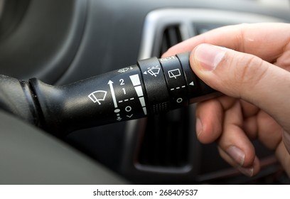 Macro photo of driver adjusting windscreen wipers control toggle