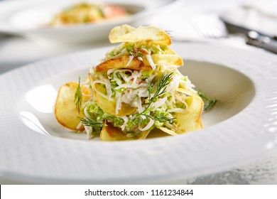 Macro Photo Of Exquisite Serving Salad With Crispy Potato Chips And Chopped Strips Vegetables On Blurred Background. Restaurant Starter Menu Of Veggie Salat With Thin Sliced Fried Potatoes Close Up