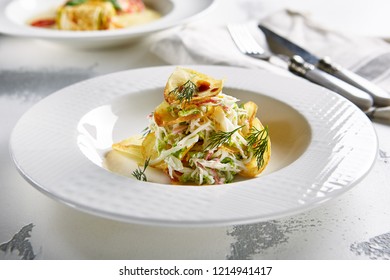 Macro Photo Of Exquisite Serving Salad With Crispy Potato Chips And Chopped Strips Vegetables On Blurred Background. Restaurant Starter Menu Of Veggie Salat With Thin Sliced Fried Potatoes Close Up