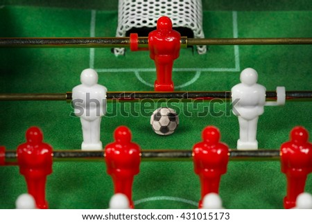 Macro photo of a mini table football game with an old black and white soccer ball