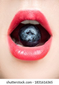 Macro Photo Of Red Lips With A Large Ripe Blueberry Berry Inside The Mouth