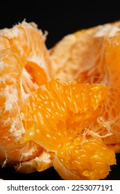 macro photo and selective focus of orange pulp on orange peel on dark background - Shutterstock ID 2253077191