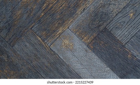 Macro Photo Of The Texture Of An Old Peeled, Scratched Grey-brown Parquet Board, Top View, Flat Lay. Repair Work On The Restoration Of The Old Parquet Floor. Herringbone Pattern. Retro Interior