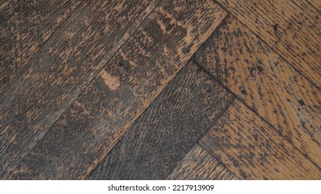 Macro Photo Of The Texture Of An Old Peeled, Scratched Grey-brown Parquet Board, Top View, Flat Lay. Repair Work On The Restoration Of The Old Parquet Floor. Herringbone Pattern. Retro Interior