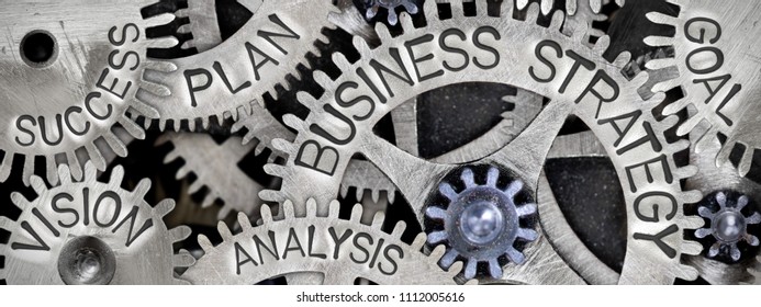 Macro photo of tooth wheel mechanism with BUSINESS STRATEGY concept related words imprinted on metal surface