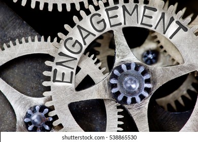 Macro photo of tooth wheel mechanism with ENGAGEMENT concept letters