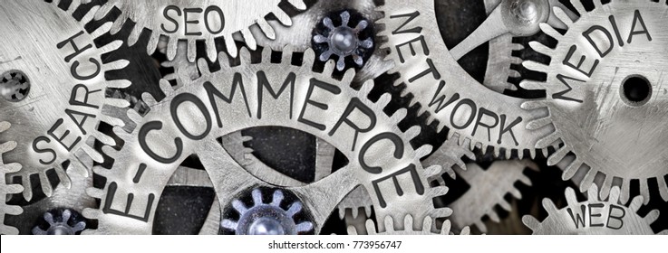Macro photo of tooth wheel mechanism with E-COMMERCE concept related words imprinted on metal surface