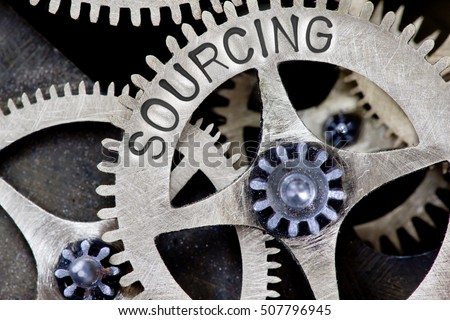 Macro photo of tooth wheel mechanism with SOURCING concept letters