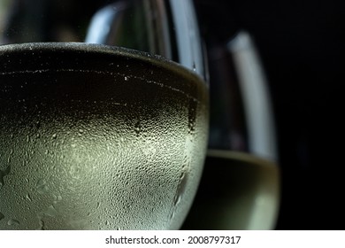 macro photo of two glasses of white wine. Two glasses with chilled wine in it and condensation