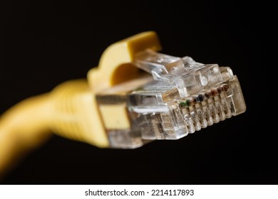 Macro Photo Of A Yellow 8 Pin Ethernet Plug On A Black Background