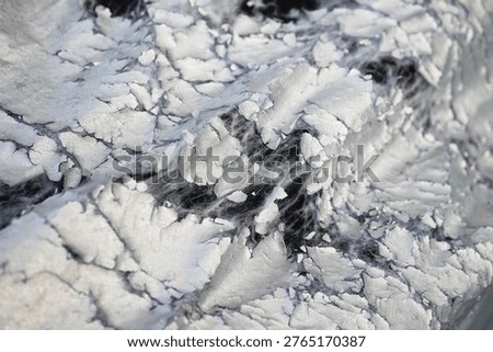 macro photograph capturing the profound disintegration and layered decay of a weathered, metallic-silver protective material