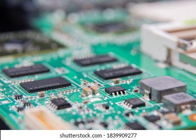 Macro photograph of green circuitboard with various components and integrated circuits
