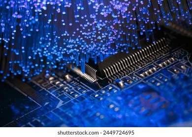 Macro photograph of a printed circuit board with a processor and optical fibers illuminating the board