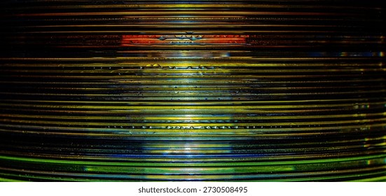 a macro photograph of a stack of compact discs, taken from a sideways view