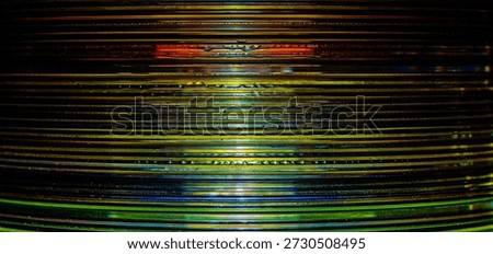 a macro photograph of a stack of compact discs, taken from a sideways view