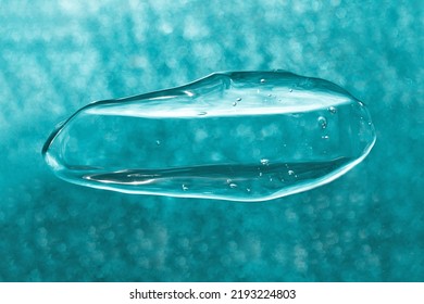 Macro Photography Of Bubbly Smear On Cyan Glitter Background.