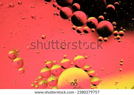 Macro photography with circles oil droplets water surface. Abstract with yellow, black and red background with oil bubbles
