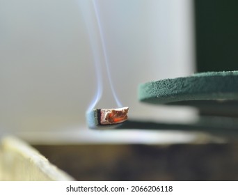 Macro Photography Of Coiled Mosquito Coils With Thin Smoky Red Embers In A Room