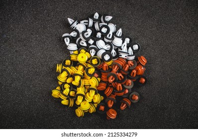 Macro photography of plastic multi-colored clips for a car on a gray background. Car clips, plastic fasteners, multicolored plastic clips on a gray background close-up.Car clips and fasteners.
