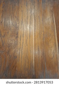 Macro photography of a solid timber tabletop in a diner, revealing detailed woodgrain patterns, lines, and knots as an abstract natural backdrop.
